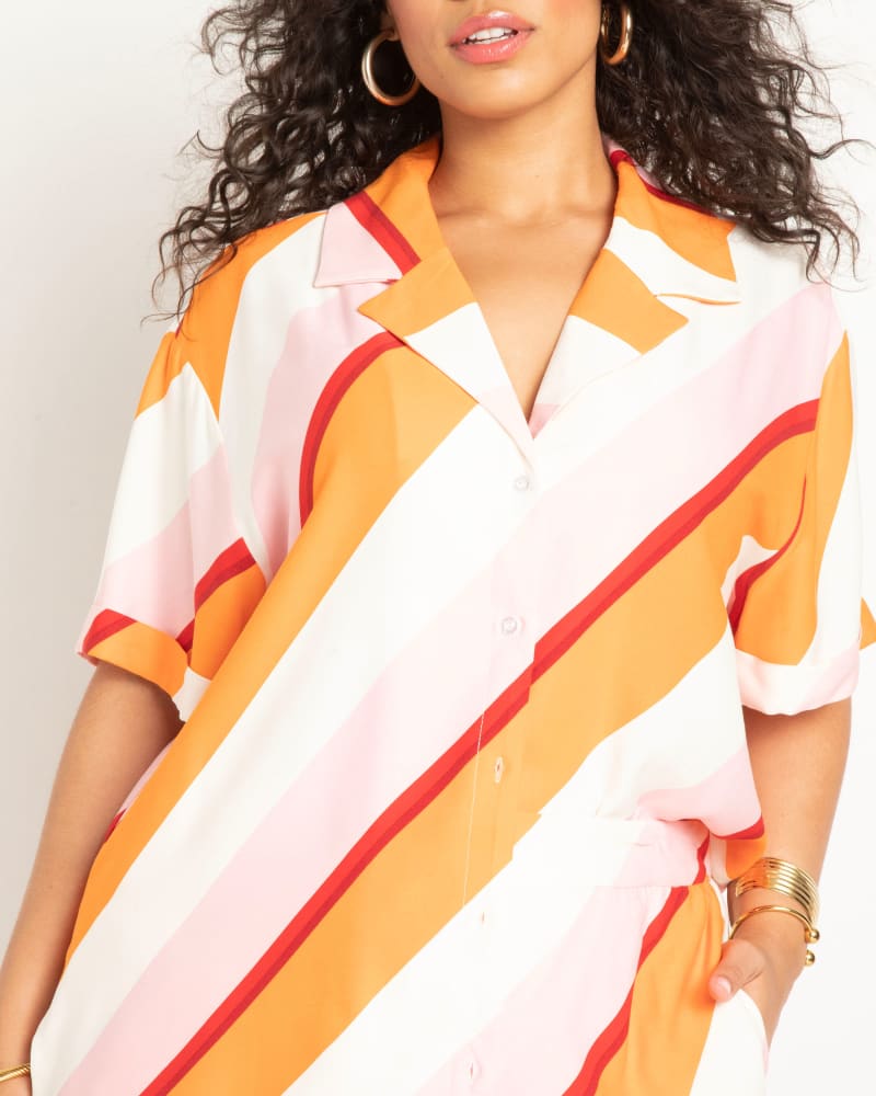 Side of a model wearing a size 22 Relaxed Short Sleeve Button Down in Candy Stripe by ELOQUII. | dia_product_style_image_id:300085